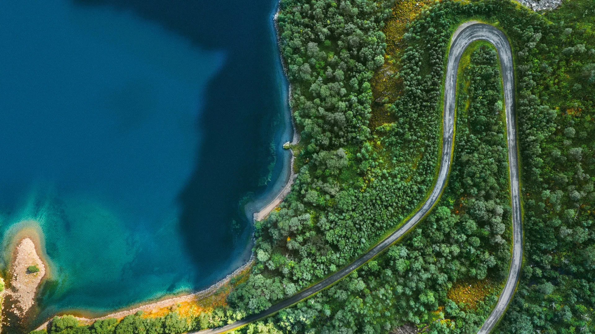 Panoramic Norwegian fjord landscape with mountains, water, and a small village nestled on the shore