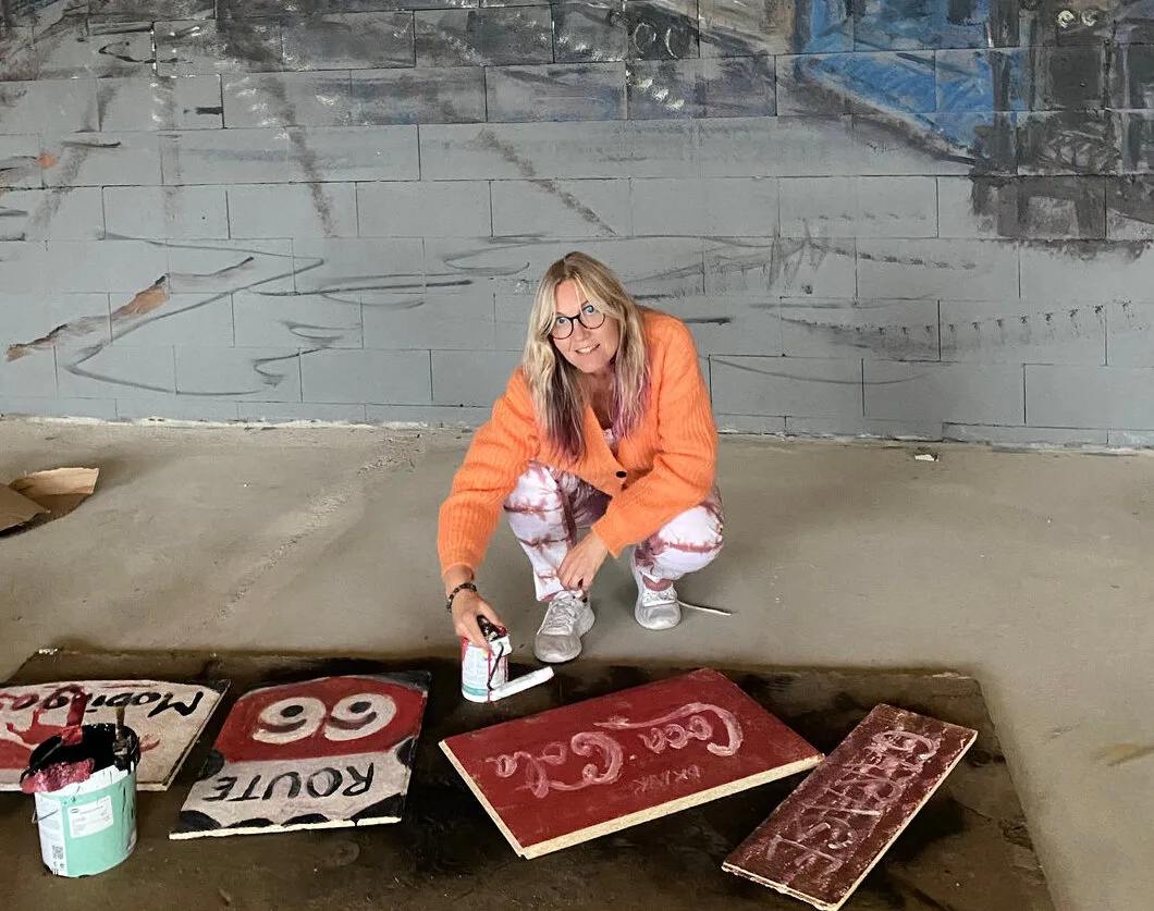 Linda Nogva painting a mural