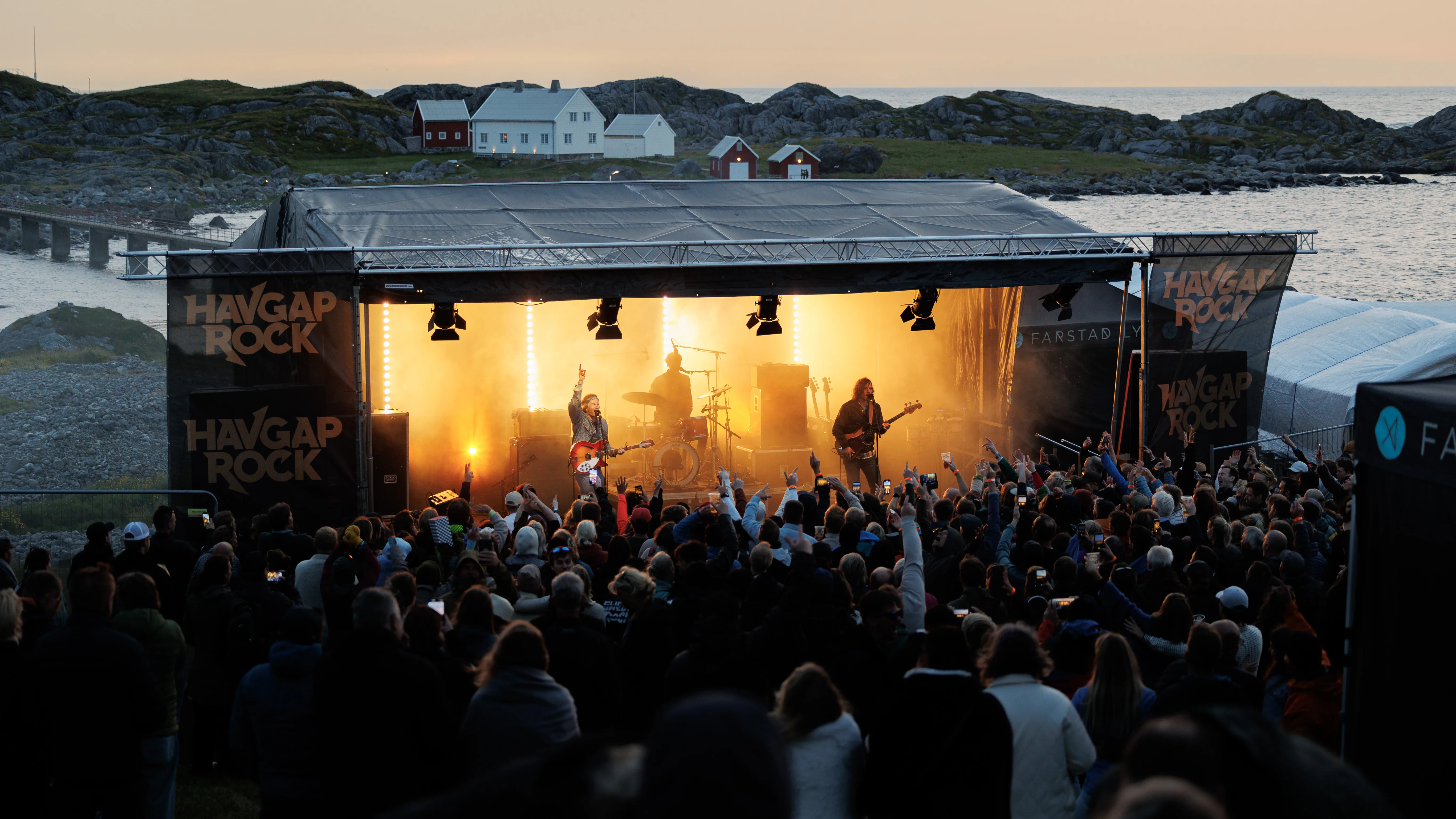 The Havgaprock festival stage by the open sea at Ulla Lighthouse, with the crowd enjoying live music at sunset