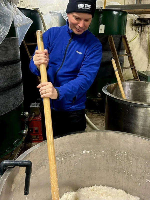 Master brewer Torkjel Austad stirring a large vat in the brewery during sake production