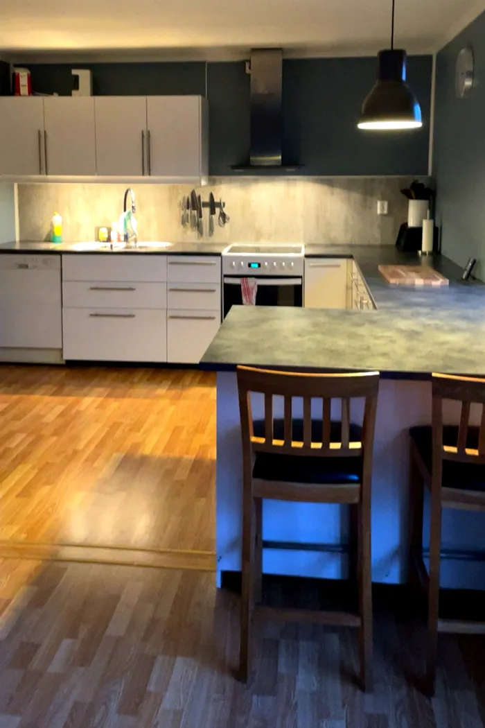 A newly renovated kitchen with modern white cabinets and wooden countertop in Adrian's countryside home