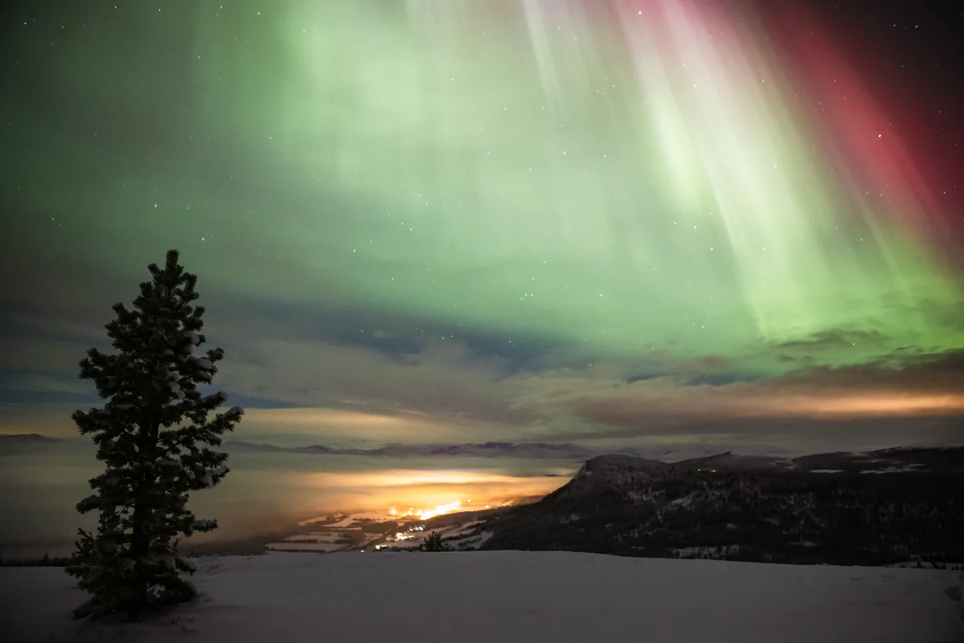 Spectacular northern lights dancing across the sky over Folldal village at night