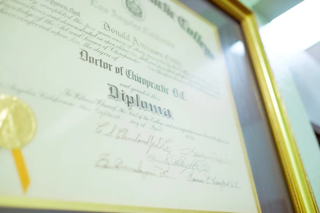 Close-up of a diploma document with a red wax seal and ribbon