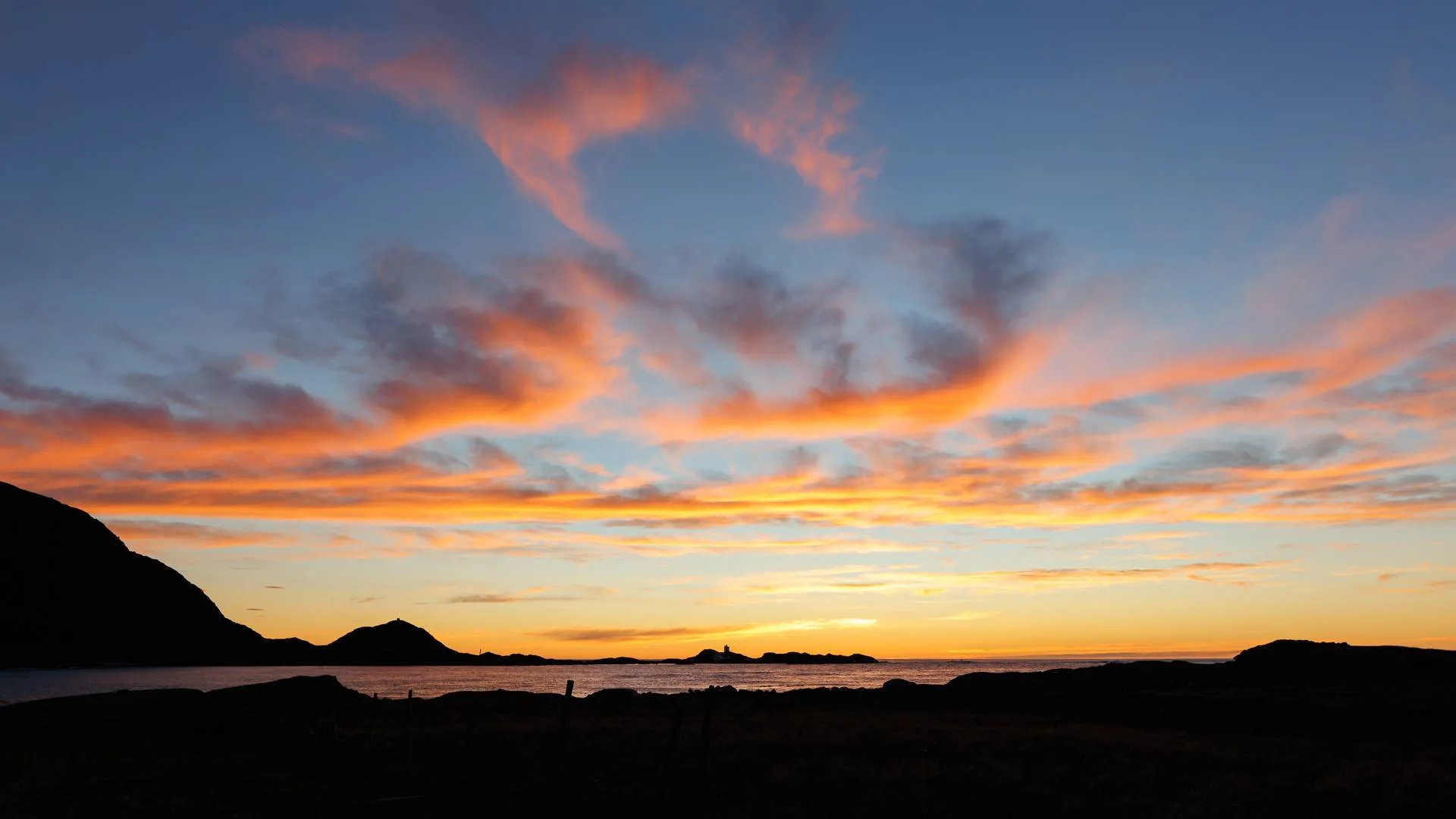 Golden sunset over the ocean at Nordøyane with islands silhouetted on the horizon