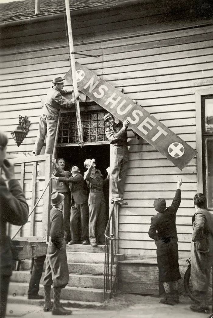 The hated NS (Nasjonal Samling) sign being taken down from a building in Halden on Liberation Day