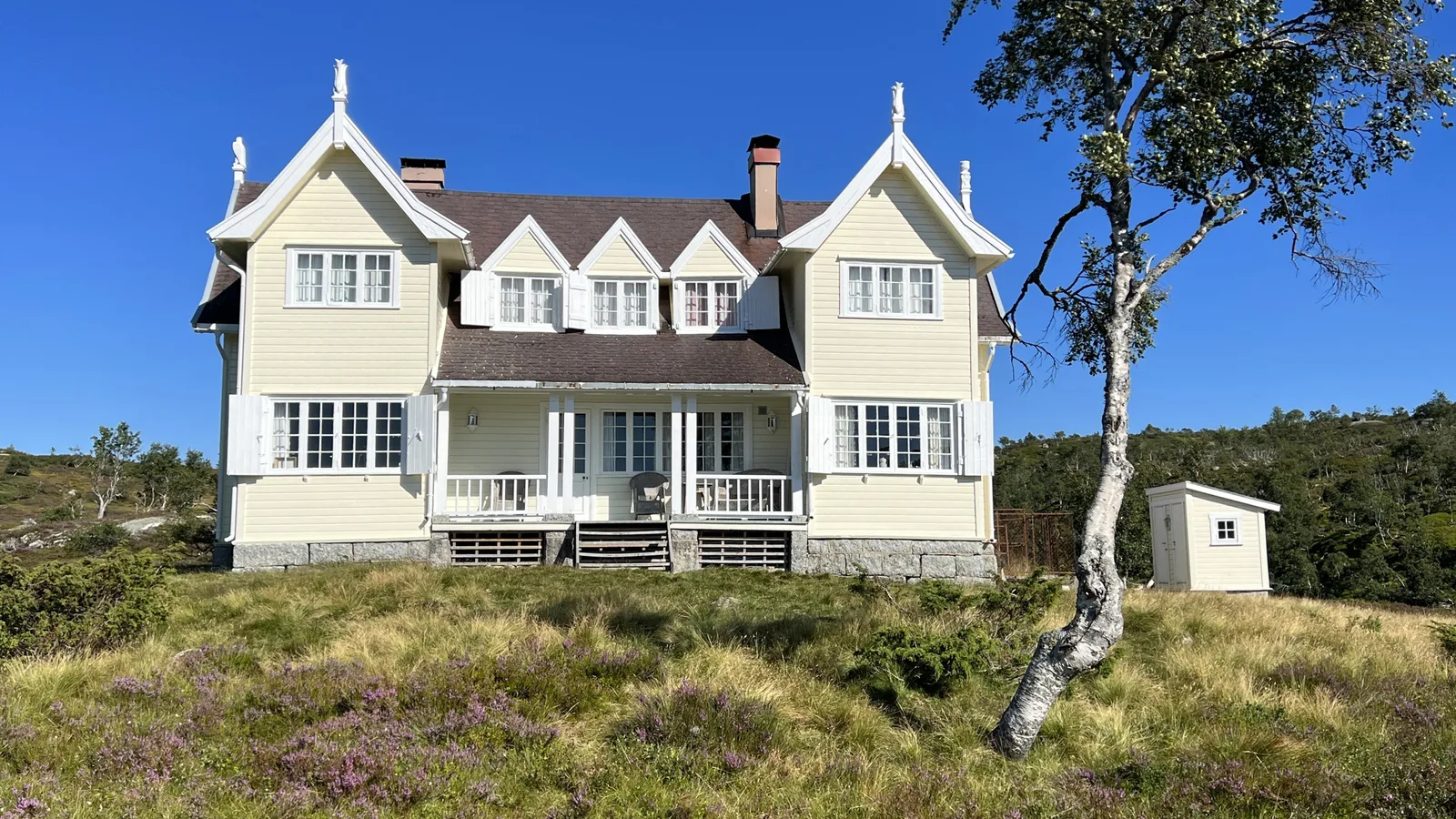 Lordehytta, a majestic wooden hunting lodge with nine gables, standing alone by a mountain lake in the Åseral highlands