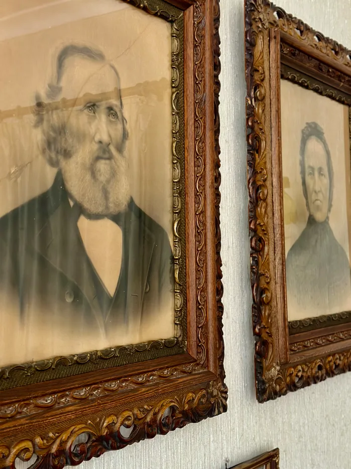 Black and white framed photographs of Rune Løyning's great-grandparents hanging on the wall at Oldemors Hus