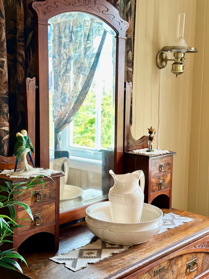 Mirrored chest of drawers with vase and bowl from great-grandmother's house, featuring original 1920s furniture