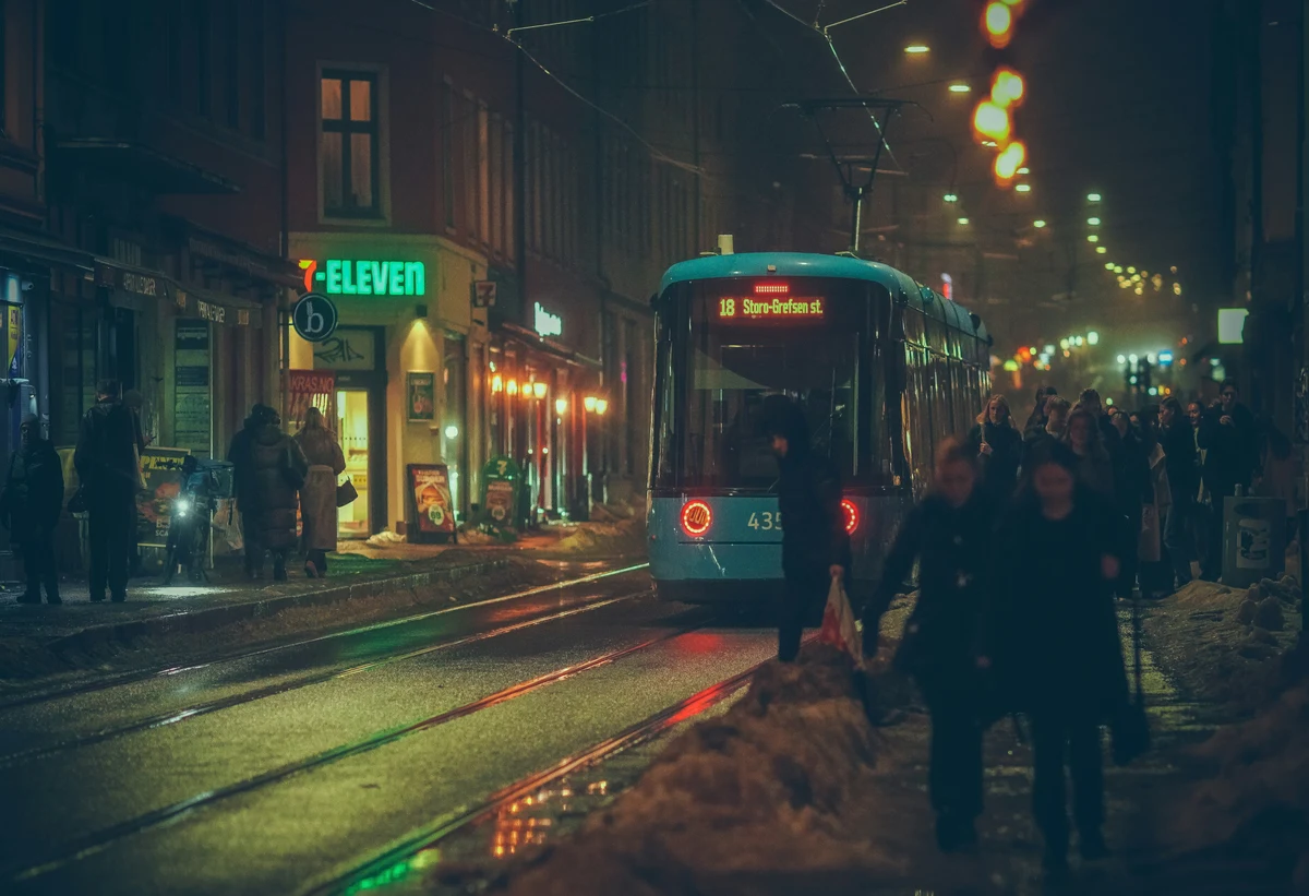 Dark and moody view of Oslo at night with dim streetlights reflecting on wet cobblestones