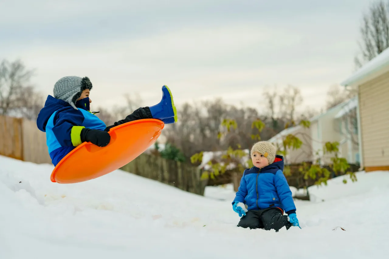 Children playing joyfully in fresh winter snow