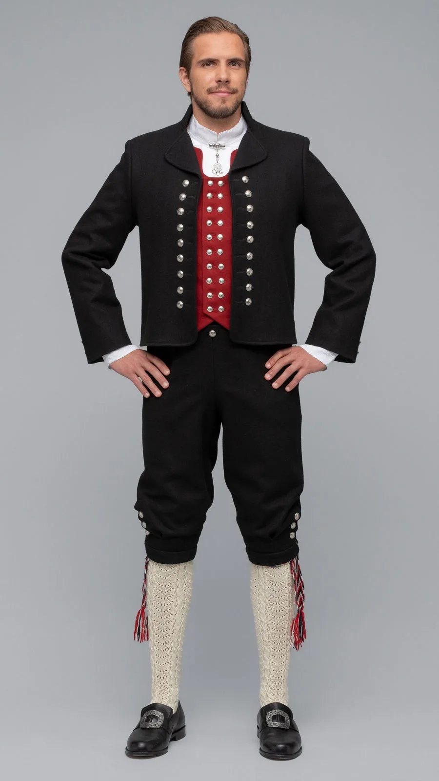 The traditional Sunnmøre men’s bunad with black jacket, red vest, and knee-length breeches