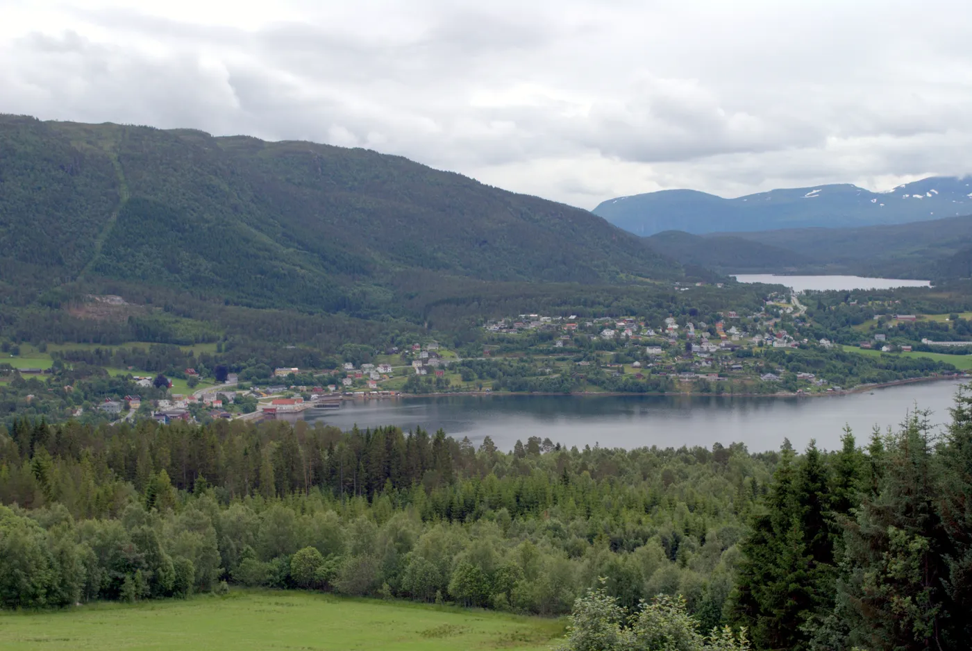 Aerial view of Tingvollvågen village by the fjord, surrounded by green hills