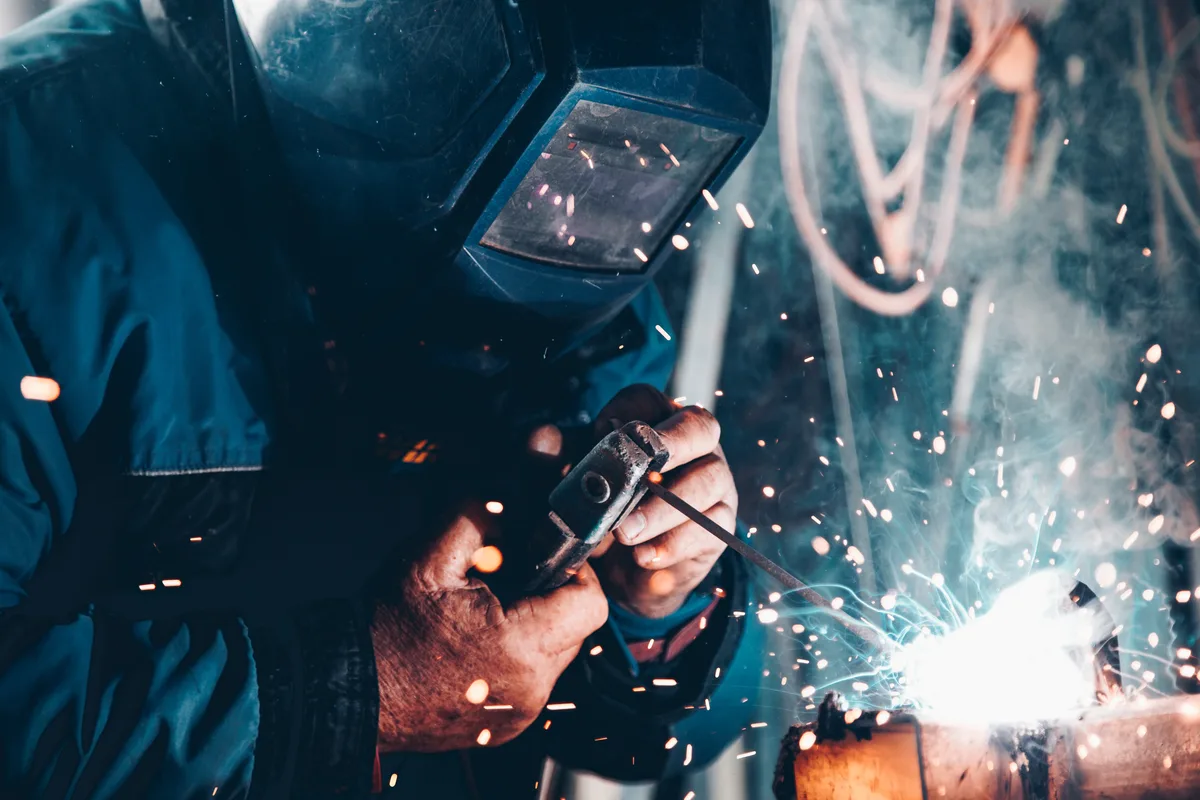 A skilled welder at work, sparks flying, wearing protective gear