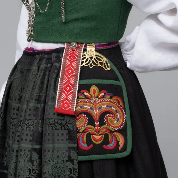 Close-up mosaic of Vest-Agder bunad details showing silver clasps, embroidered cuffs, and colourful silk scarf knot
