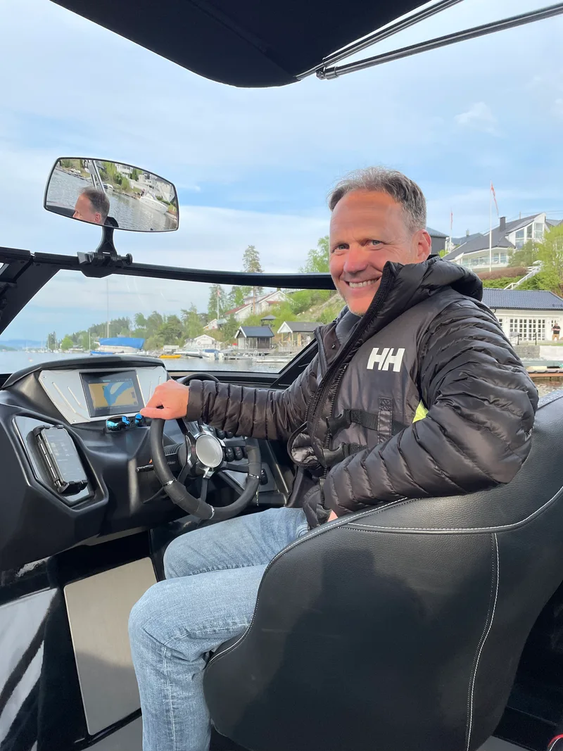 Gisle Erichsen standing in his wakesurfing boat on lake Krøderen, ready for action