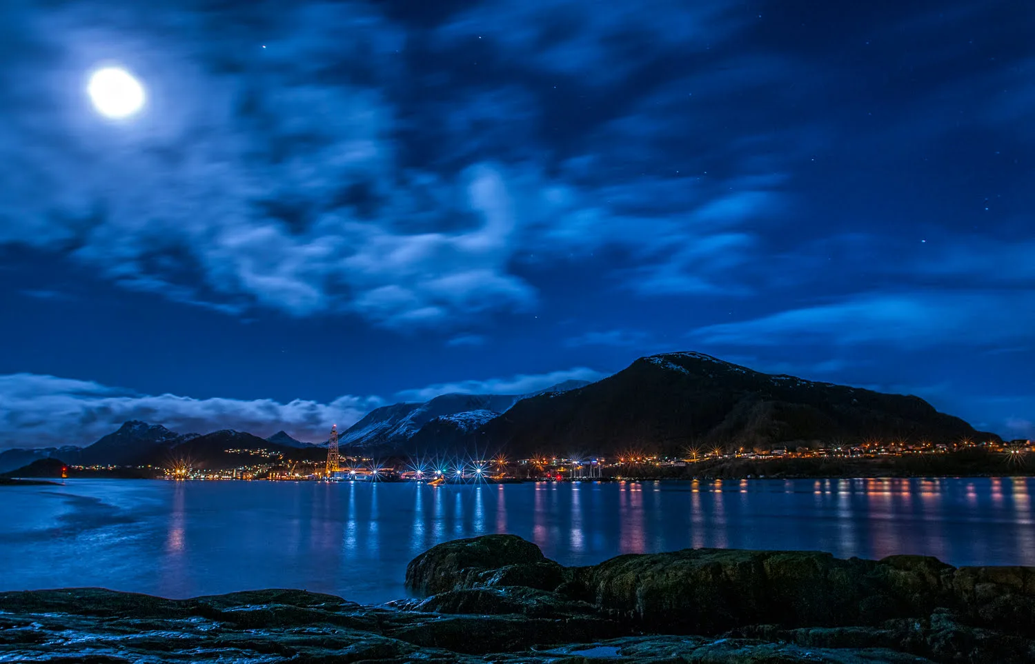 Brattvåg shoreline lights reflected on the calm Samfjorden at night