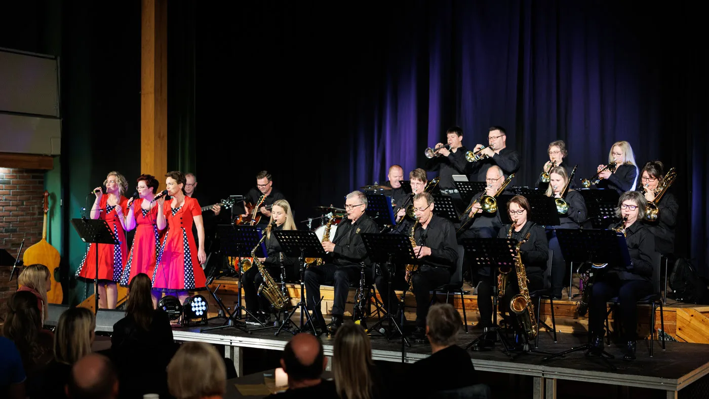 A concert with a variety of wind instruments and three singers