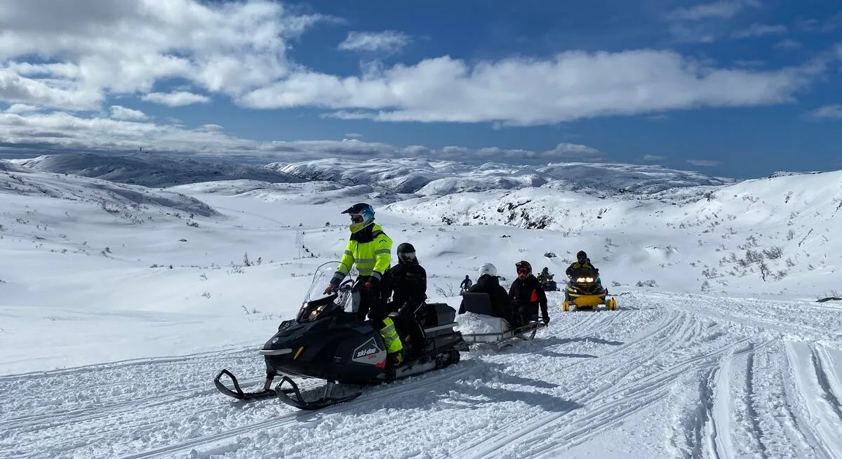 A family on a snowmobile trip through the winter landscape in Åseral