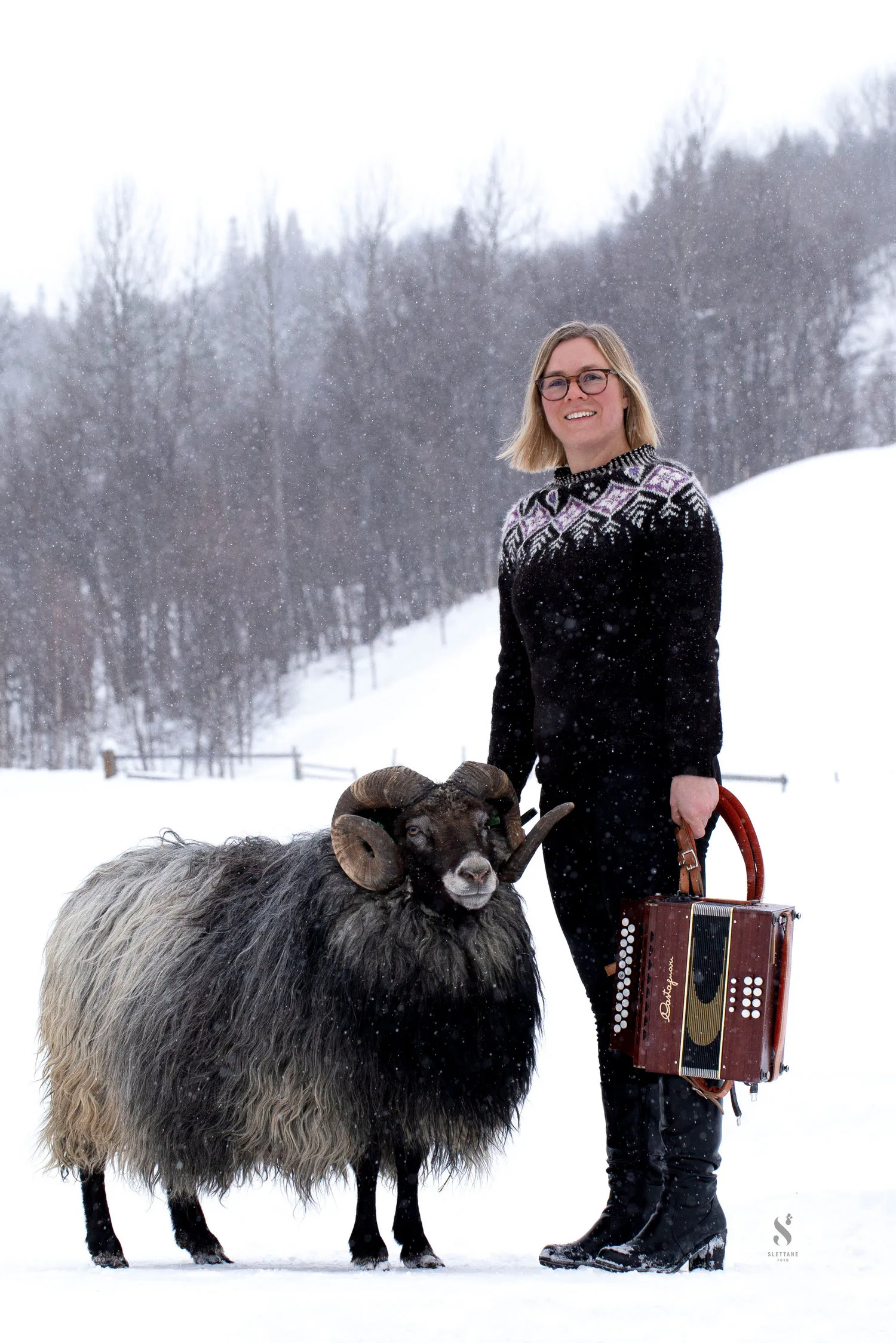 Ingunn Stræte in the snow with a sheep