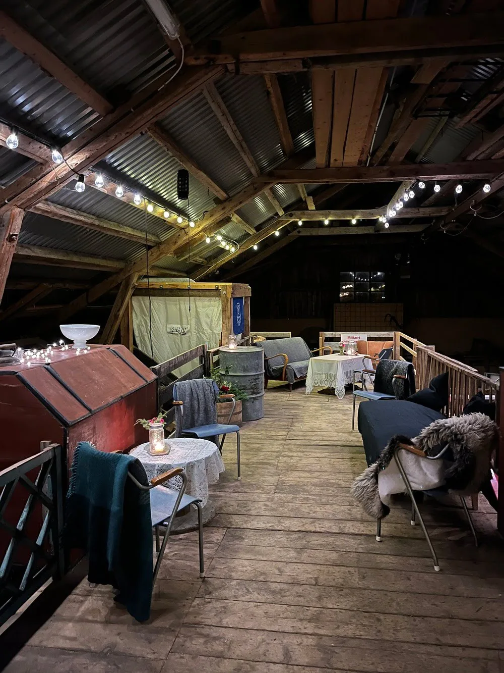 Old barn set up for a party with chairs and light