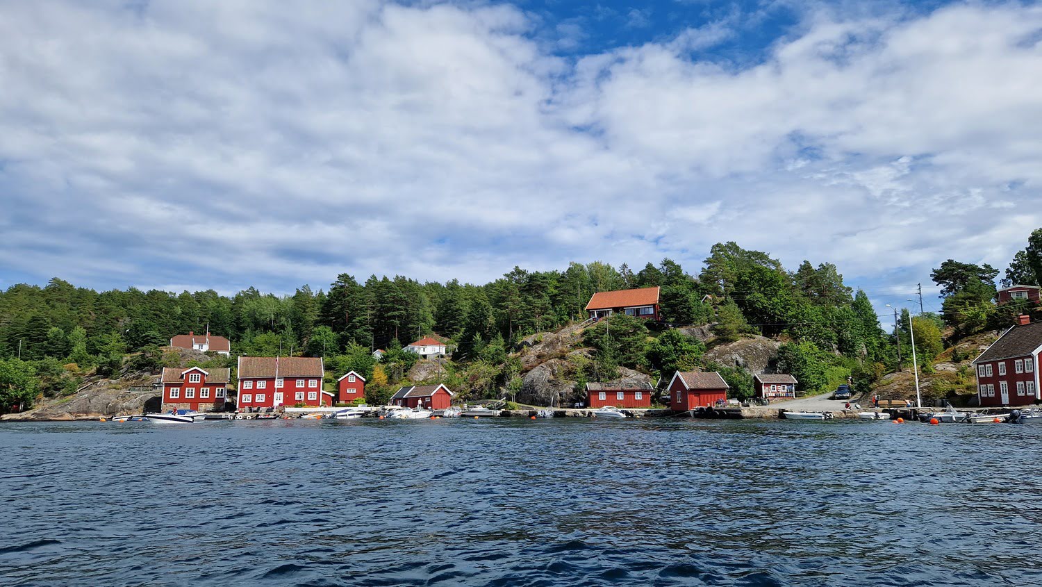 Sandøya harbor with boats and traditional wooden houses